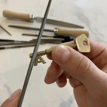 The handmade brass A key from the Andrew the Locksmith logo, cut by hand