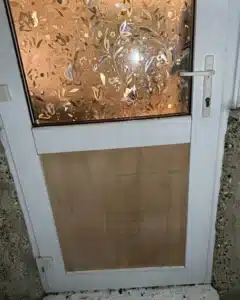 The same uPVC door boarded up and made secure after the break-in in Harrow