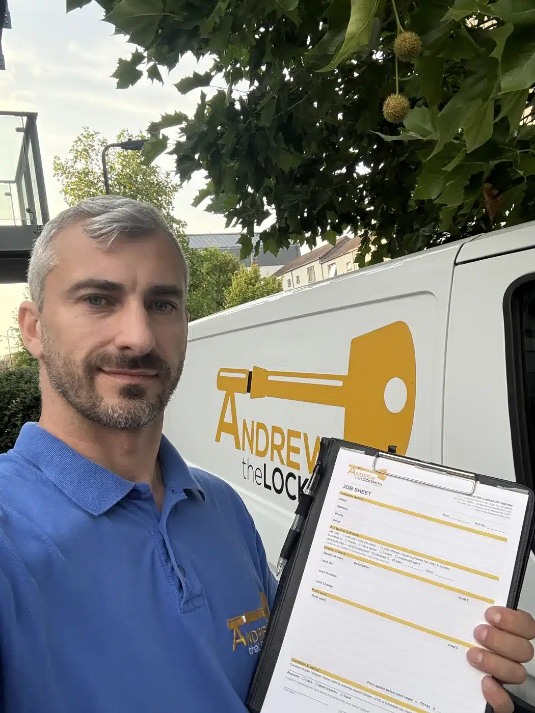 Andrew the Locksmith beside his branded van in Harrow with a job sheet, ready to give a clear price