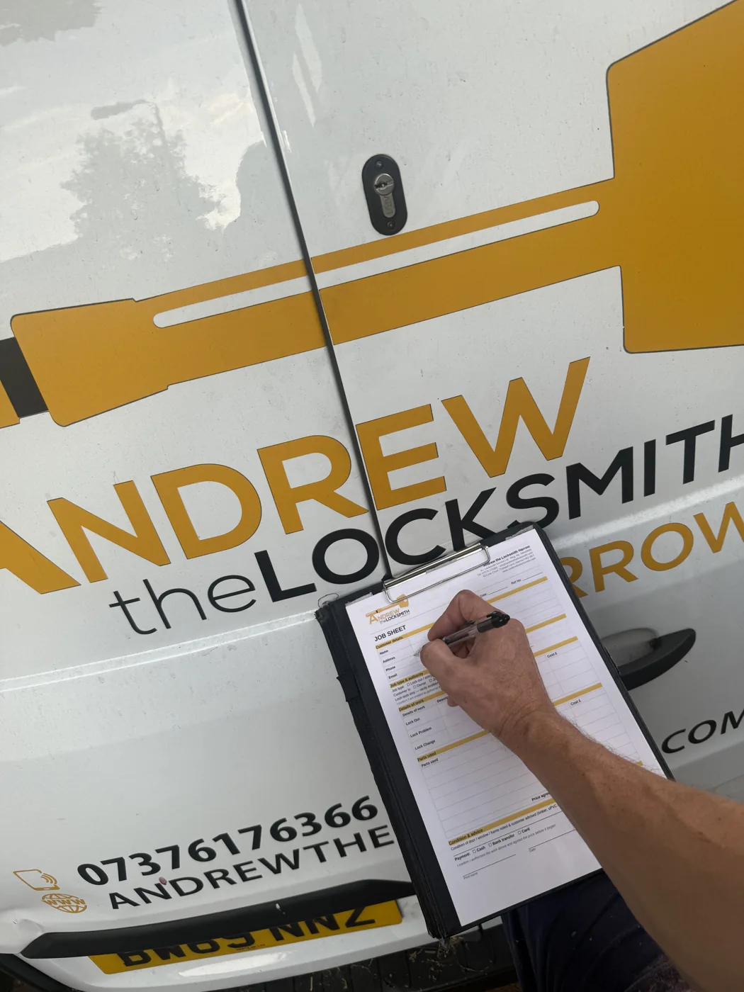 Andrew filling in a job sheet with the agreed locksmith cost before starting work in Harrow