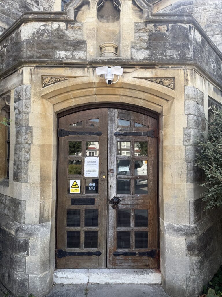 The double timber doors at St Peter's Church in Harrow hanging square in their stone arch after realignment