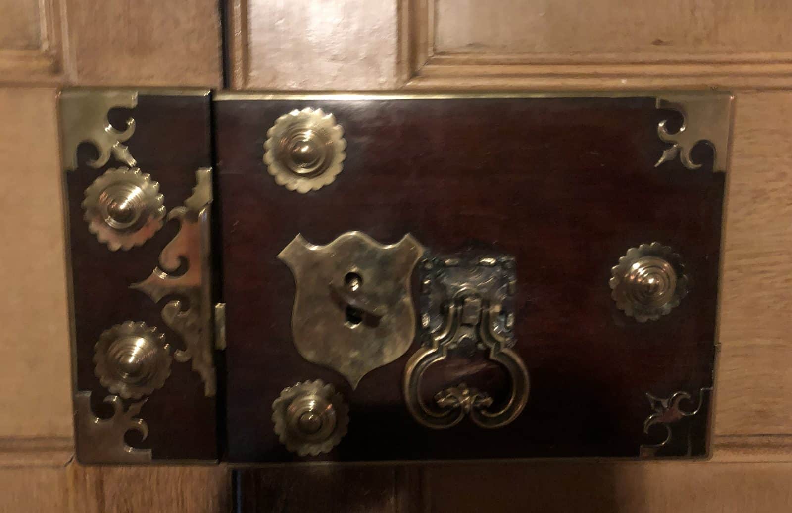 Antique lock with brass corners, domed studs and a brass keyhole shield on an old wooden door in Harrow on the Hill, rekeyed and repaired by Andrew the Locksmith